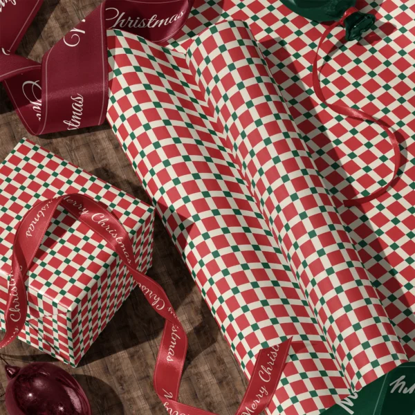 Rolls of red tile check gift wrap and a wrapped box with satin ribbons on a wooden floor