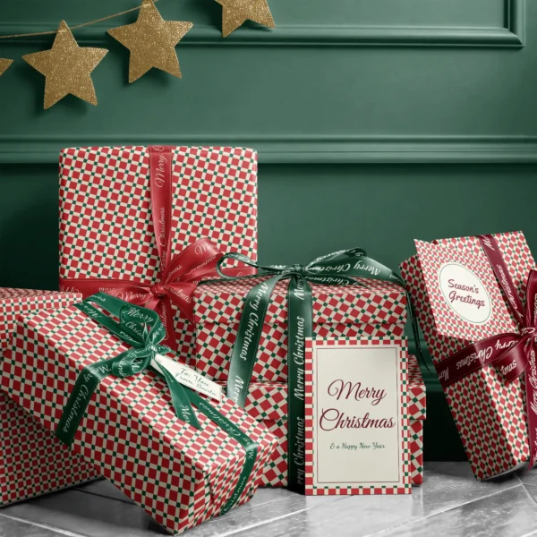Stack of presents in red tile check paper with ribbons and a Merry Christmas card by a dark green wall