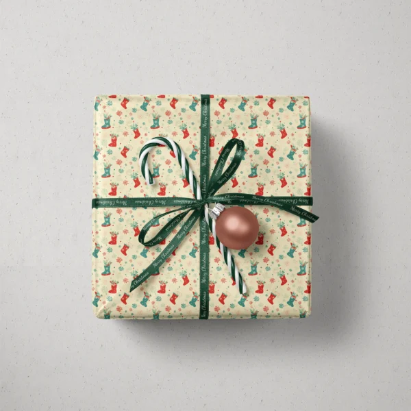 Top view of a gift in cream Christmas stocking paper with a ribbon, a candy cane and a bauble