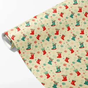Roll of cream wrapping paper with red and teal Christmas stockings full of holly and pine, partly unrolled on white