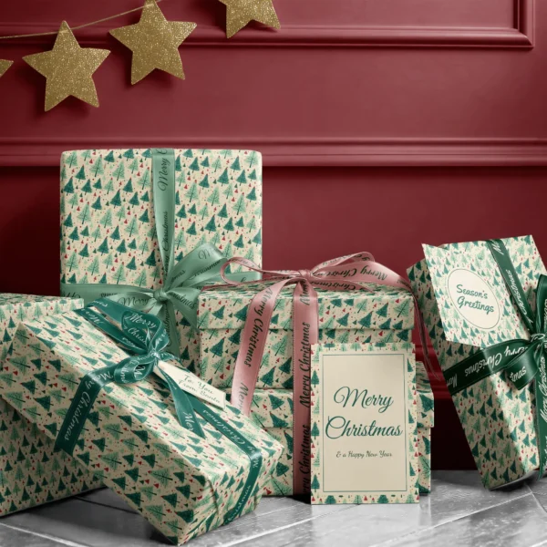 Stack of presents in cream retro green tree paper with ribbons and a Merry Christmas card by a burgundy wall