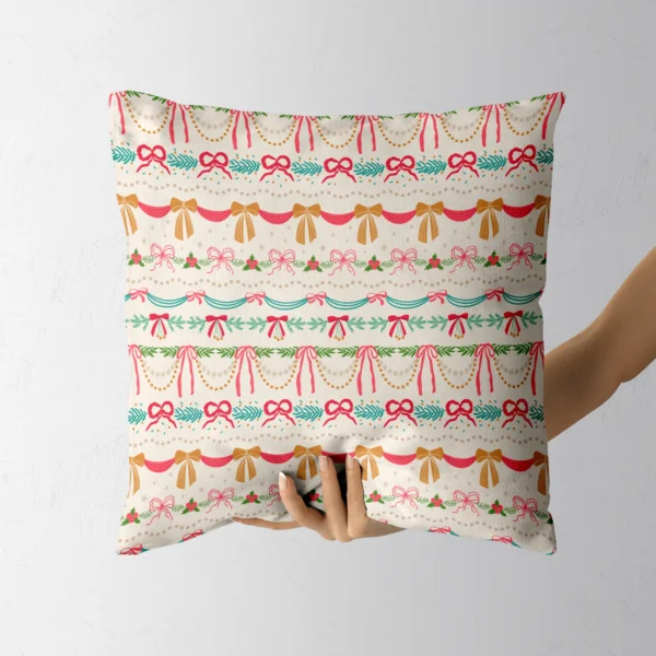 Hand holding the cream pillow with bands of bows and bunting