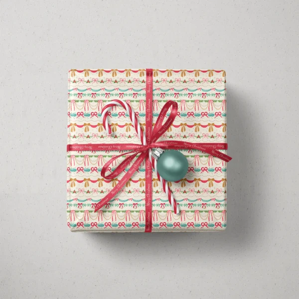 Top view of a gift in ribbon swag paper with a ribbon, candy canes and a bauble