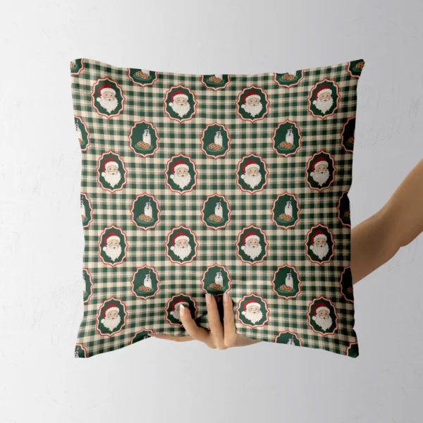 A hand holding the green gingham Santa throw pillow