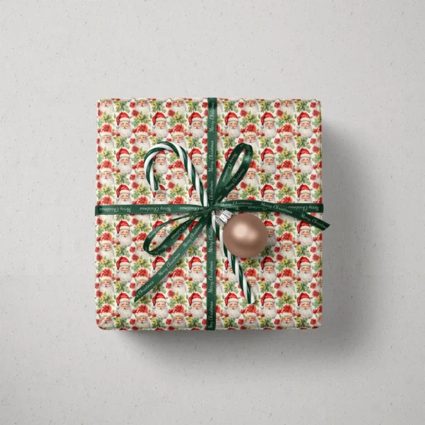Top view of a gift in Santa and poinsettia paper with a ribbon, a candy cane and a bauble