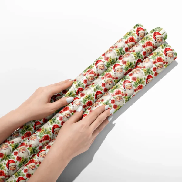Hands smoothing three rolls of Santa and poinsettia wrapping paper on a white table
