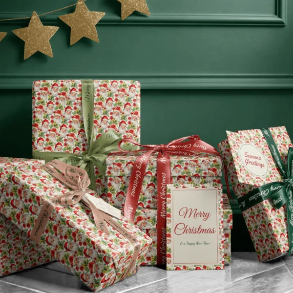 Stack of presents in Santa and poinsettia paper with ribbons and a Merry Christmas card by a dark green wall