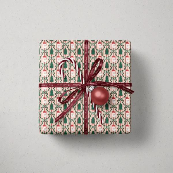 Top view of a gift in Santa trellis paper with a ribbon, candy canes and a bauble