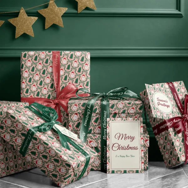 Stack of presents in Santa trellis paper with ribbons and a Merry Christmas card by a dark green wall