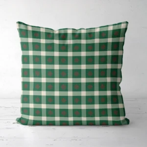Snowflake gingham Christmas pillow seen from the front, red flakes on green check