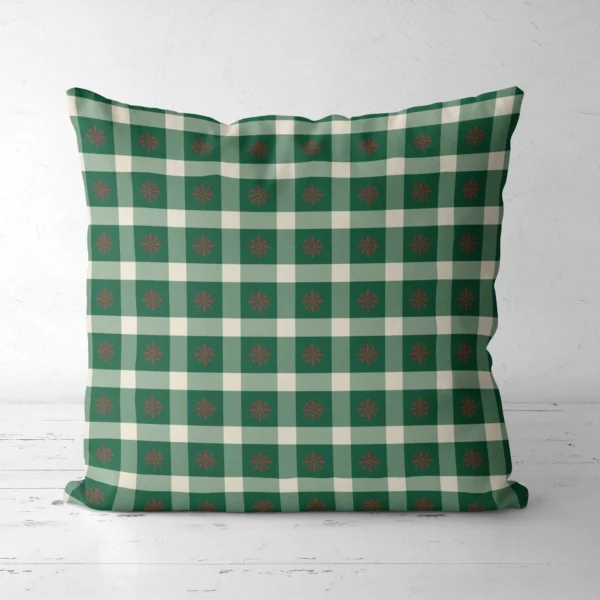 Snowflake gingham Christmas pillow seen from the front, red flakes on green check