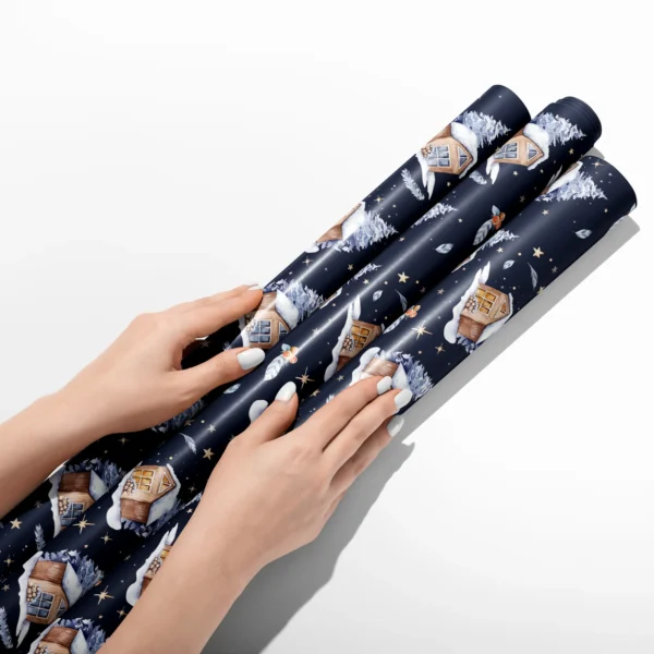 Hands smoothing three rolls of navy night cabin wrapping paper on a white table