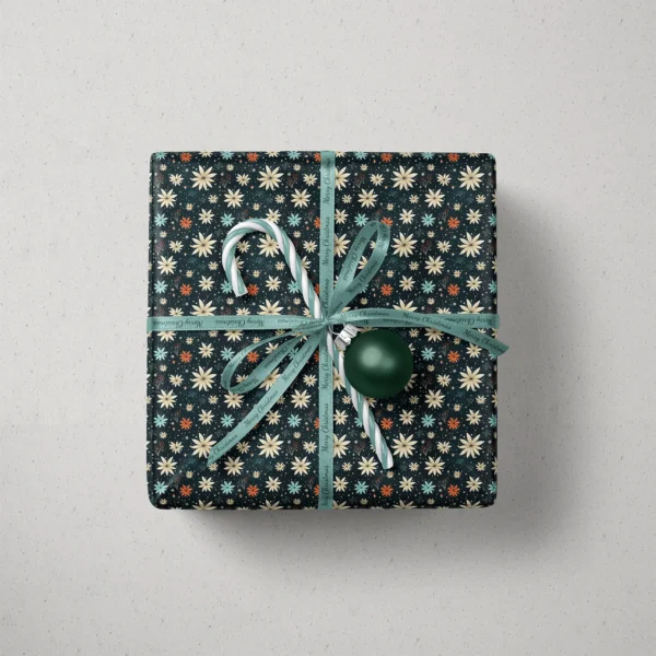 Top view of a gift in midnight starflower paper with a ribbon, a candy cane and a bauble