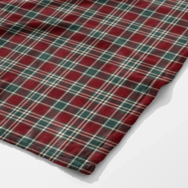 Corner close-up of the tartan Christmas plush blanket showing the soft velveteen surface