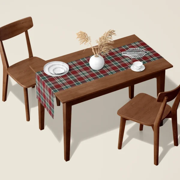 Burgundy and green tartan table runner on a walnut dining table with two wooden chairs