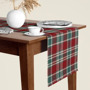 Burgundy and green tartan table runner hanging over the end of a walnut dining table, close-up