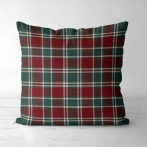 Burgundy and green tartan Christmas pillow, front view, standing on a white floor