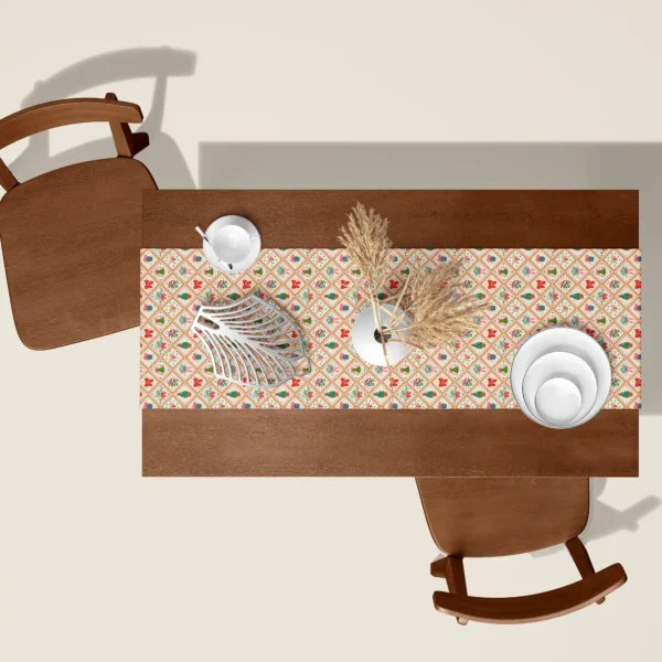 Vintage gold tile Christmas table runner seen from above on a walnut table with white dishes and dried pampas