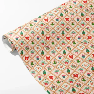 Roll of cream wrapping paper with gold diamond frames holding small trees, mistletoe and gifts, partly unrolled on white