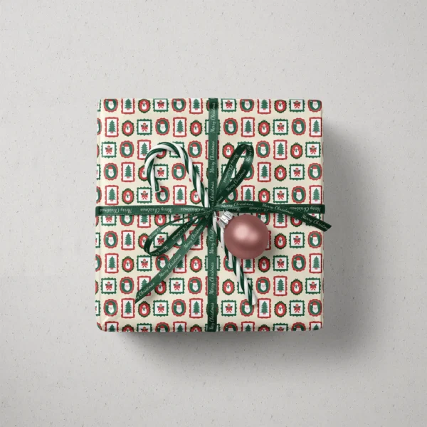 Top view of a gift in vintage frames paper with a ribbon, candy canes and a bauble