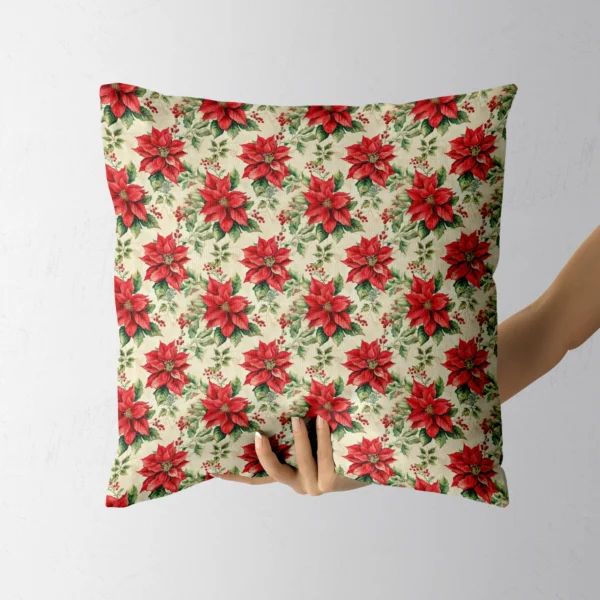 Hand holding the square cream poinsettia and holly pillow