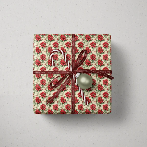Top view of a gift in vintage poinsettia paper with a ribbon, a candy cane and a bauble