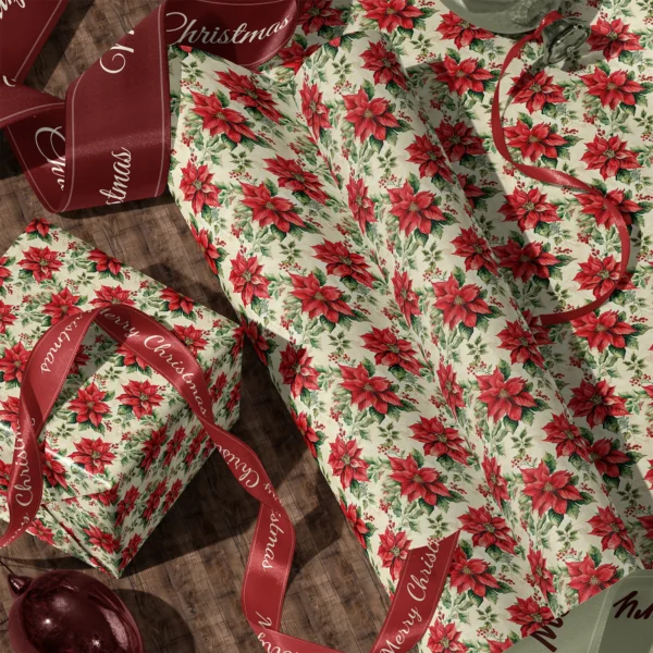 A sheet of vintage poinsettia gift wrap and a wrapped box with satin ribbons on a wooden floor