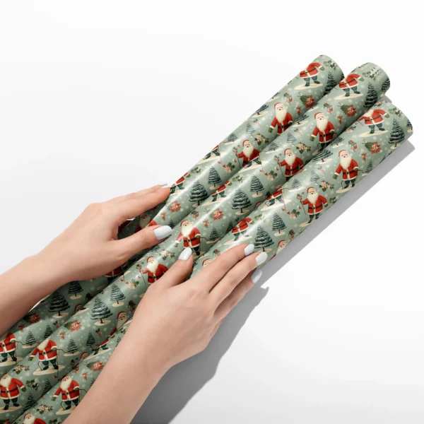 Hands smoothing three rolls of sage vintage Santa wrapping paper on a white table