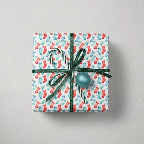 Top view of a gift in watercolor stocking paper with a ribbon, a candy cane and a bauble