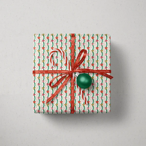 Top view of a gift in wavy garland paper with a ribbon, candy canes and a bauble