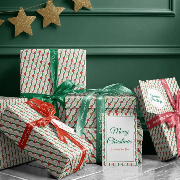 Stack of presents in wavy garland paper with ribbons and a Merry Christmas card by a dark green wall