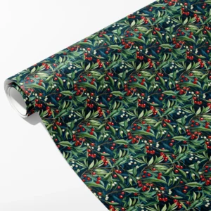 Roll of navy wrapping paper with red and white berries on green leafy branches, partly unrolled on white