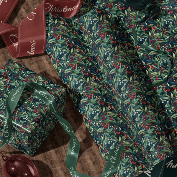 A sheet of navy winter berry gift wrap and a wrapped box with satin ribbons on a wooden floor
