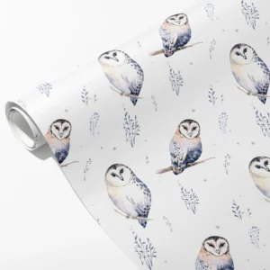 Roll of white wrapping paper with watercolor owls perched on branches and frosty blue sprigs, partly unrolled on white