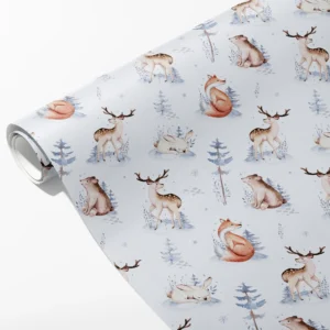 Roll of pale blue wrapping paper with watercolor deer, foxes, bears and rabbits among snowy firs, partly unrolled on white